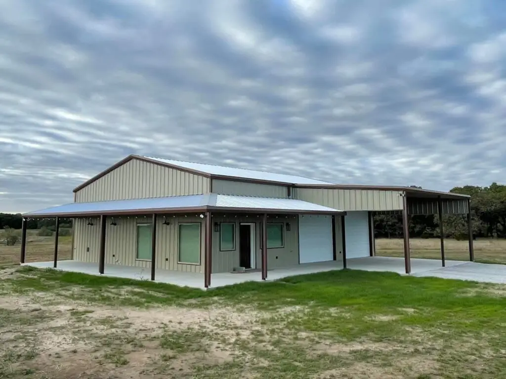 cream colored barndominium with brown gutters