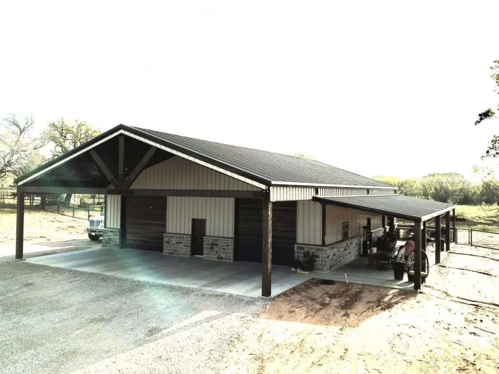 tan and black barndominium with large porch