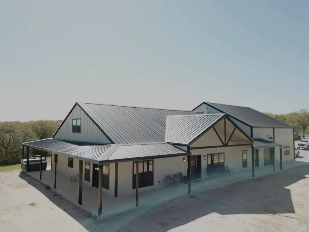 tan and silver barndominium with brown accents on the enterance.