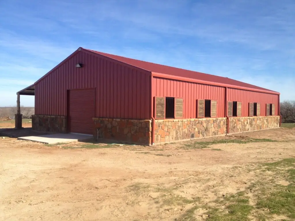 red barn barndominium with stonework half up the walls