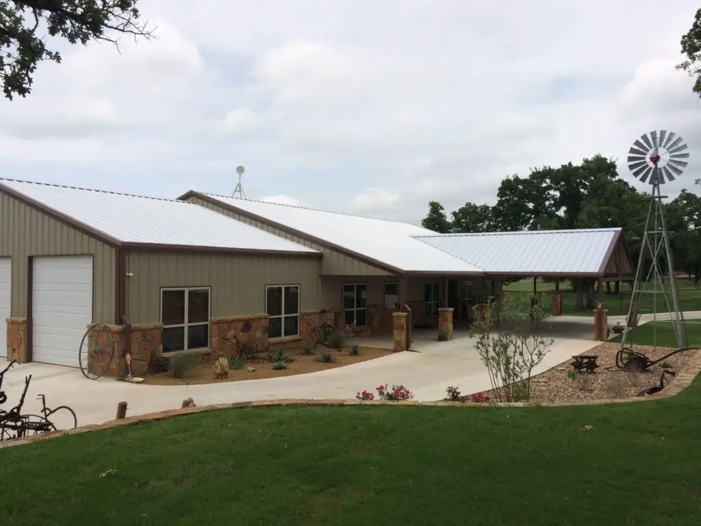 brown barndominium with tan walls and brown stone decrative siding