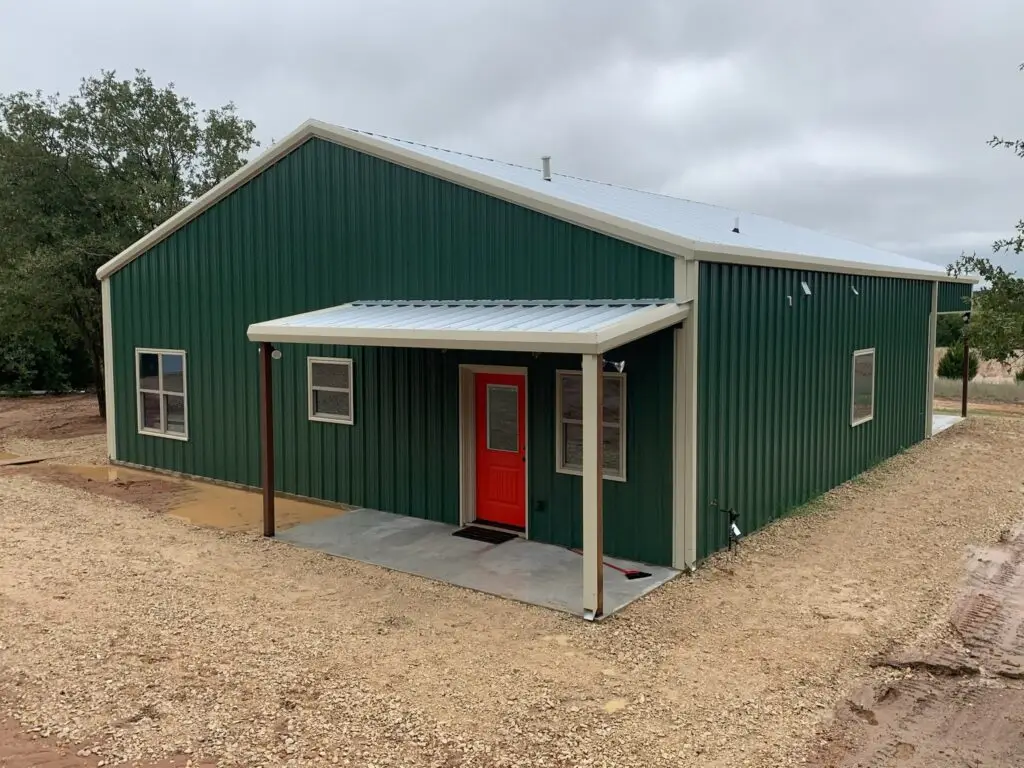 Green barndominium with bright red door