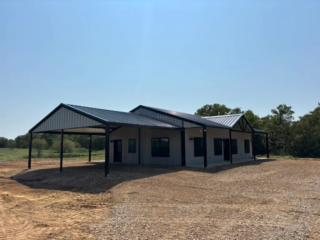 tan and black barndominium with large carport